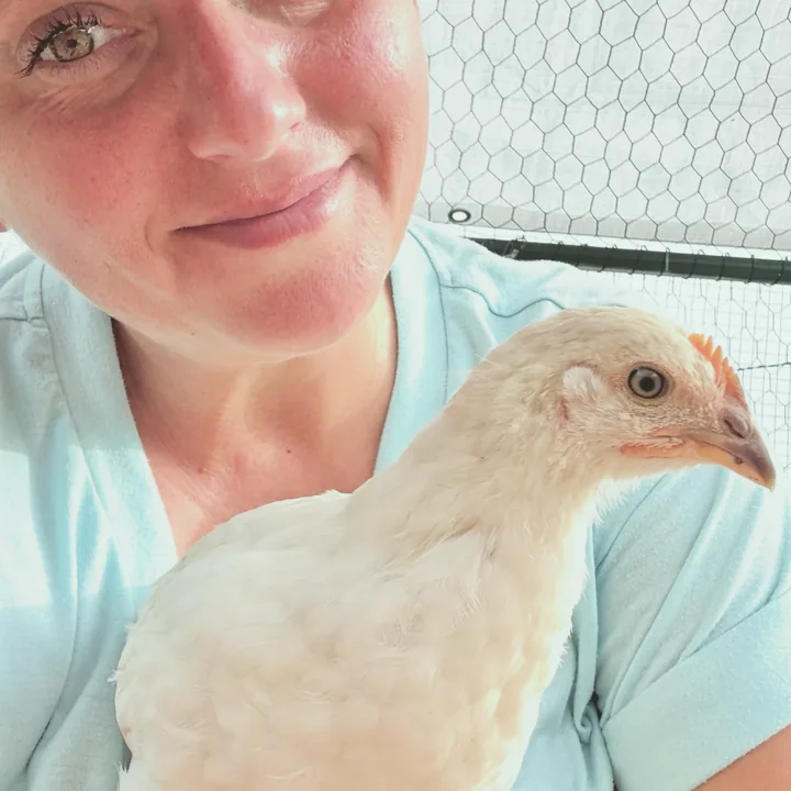 Ms. Darlin' smiling with a buff hen on her shoulder