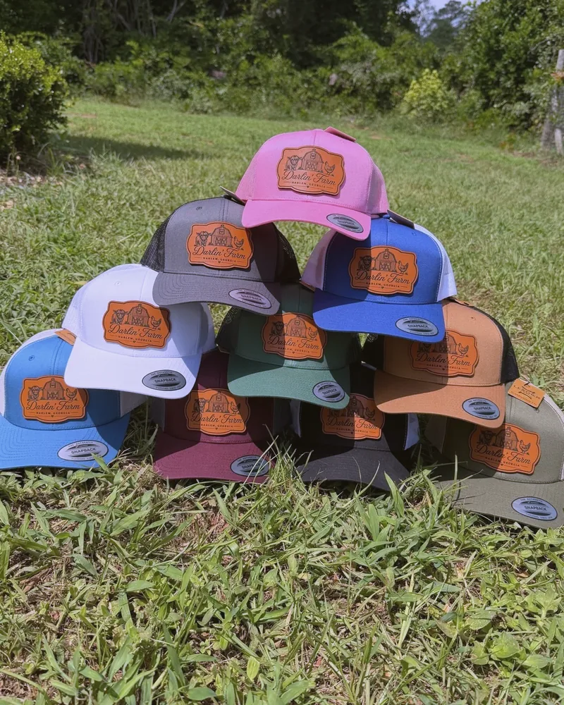 Darlin' Farm trucker hats in the grass